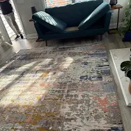 Colorful area rug freshly cleaned in living room next to teal sofa — Kim Lentz review