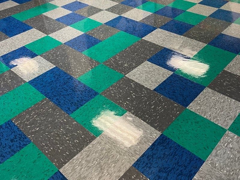 Commercial VCT floor with cleaning streaks showing Sano Steam strip and wax results
